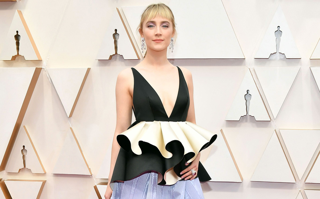 Saoirse Ronan wore a custom Gucci black, ivory and lavender gown with deep V-neck, silk duchesse waist ruffles and moiré skirt with metallic leather high heel platform sandals. She completed her look with Gucci High Jewelry earrings in white gold, spinels and diamonds, a Gucci High Jewelry ring in white gold, rubellite, pink sapphires and diamonds, Gucci High Jewelry ring in white gold, pink tourmaline and diamonds and a Gucci High Jewelry brooch in white gold, tsavorite and diamonds. 